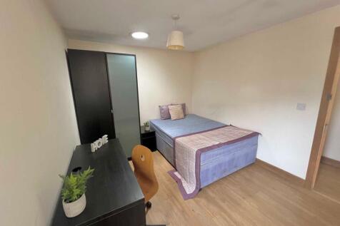 Bright, simply furnished bedroom with a double ...