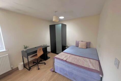 Bright, simply furnished bedroom with a double ...