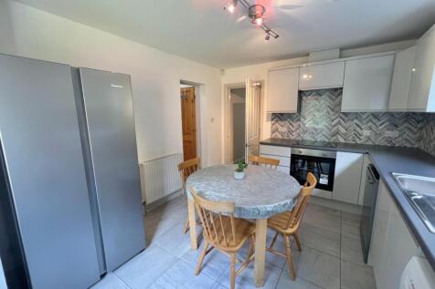 A bright and modern kitchen featuring a spaciou...
