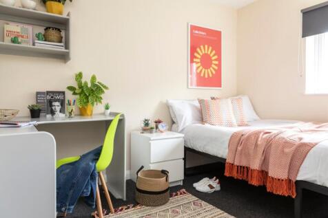 A bright and stylish bedroom featuring a cozy b...