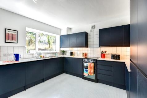 Bright, modern galley-style kitchen with dark n...