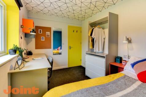 Bright and colorful student bedroom featuring a...