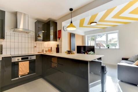 Bright modern open-plan kitchen with glossy dar...