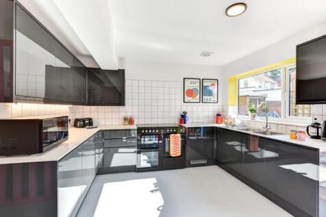 Modern and well-lit kitchen with sleek black ca...