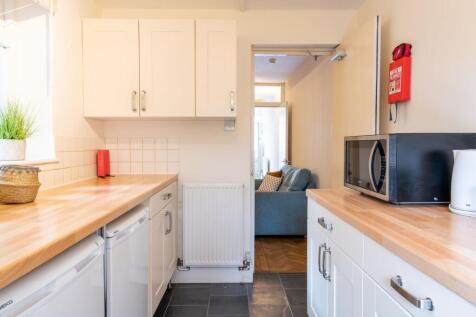 Bright galley kitchen with warm wooden worktops...