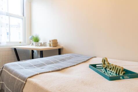 Bright, neatly styled bedroom with a comfortabl...