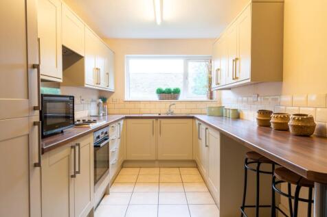 Bright, modern galley kitchen with cream cabine...