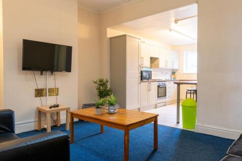 Bright open-plan living area with a mounted TV,...