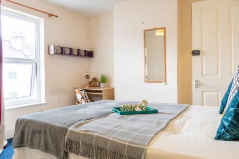 Bright, neatly styled double bedroom with a mad...