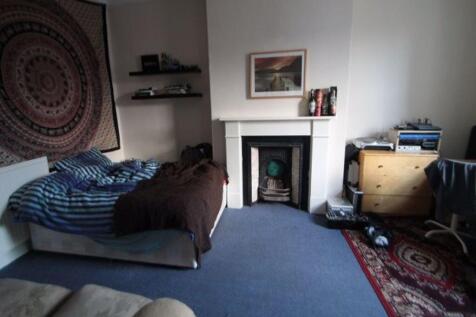 A spacious master bedroom featuring a comfortab...