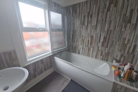 A bright bathroom suite featuring a modern bath...