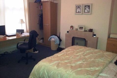 A well-lit master bedroom featuring a comfortab...