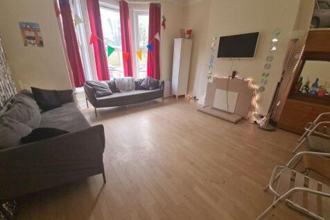 A bright and welcoming living room featuring la...