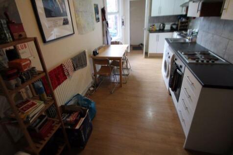 Modern kitchen with clean wooden flooring, whit...