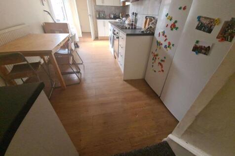 A bright kitchen featuring wooden flooring, a w...