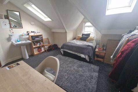 A cozy and bright single bedroom featuring a co...