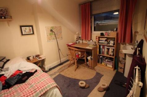 A cozy and well-used single bedroom featuring a...