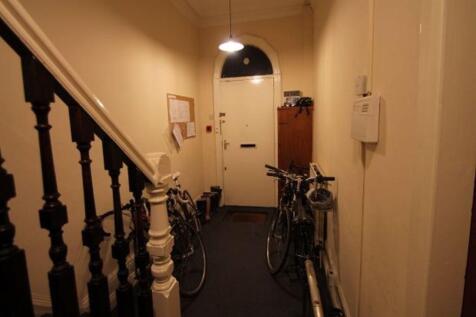 A narrow hallway featuring classic wooden banis...