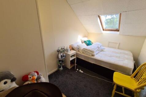 Cozy single bedroom featuring a comfortable bed...