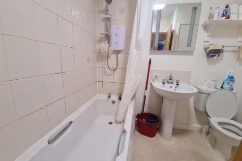 A functional bathroom featuring a bathtub with ...