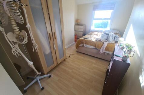 Cozy single bedroom featuring a large window th...