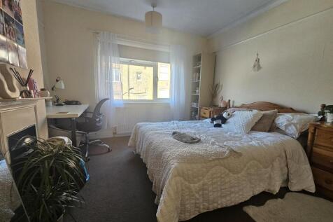 Bright and cozy master bedroom featuring a comf...