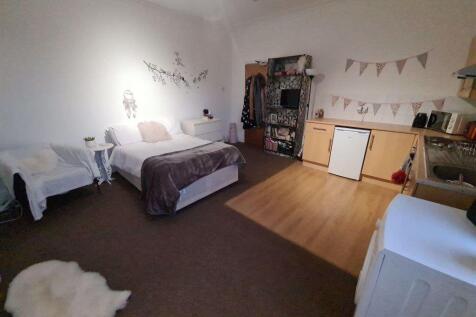 A spacious and cozy bedroom featuring a comfort...