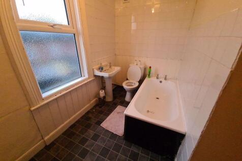 A bright and inviting bathroom with a large bat...