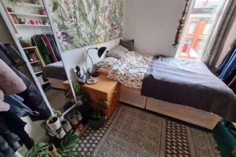 A cozy and well-lit bedroom featuring a neatly ...