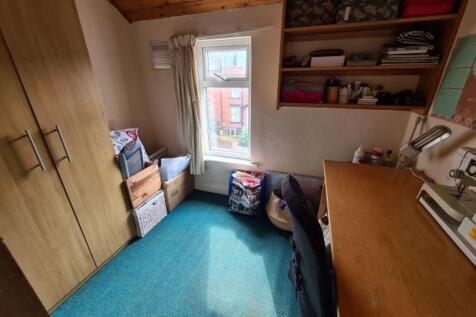 A cozy single bedroom featuring a large wooden ...