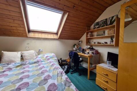 Cozy double bedroom with a colorful quilted bed...