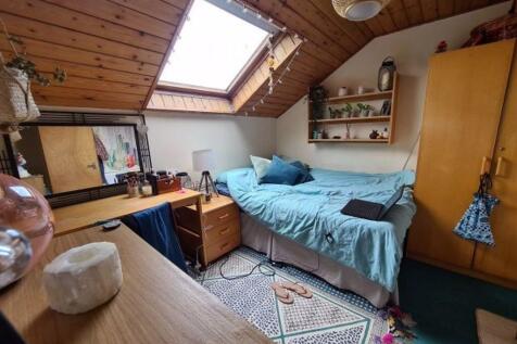 A cozy attic bedroom featuring a comfortable si...