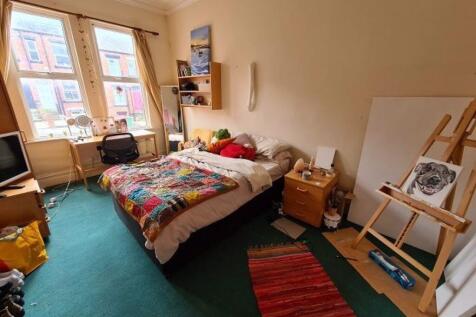 Bright and cozy bedroom featuring a comfortable...