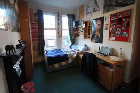 A cozy single bedroom featuring a comfortable b...