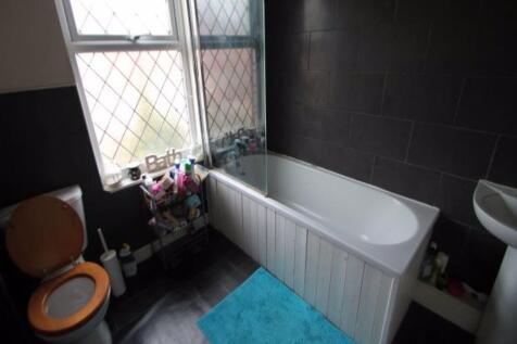 Bright bathroom with a full-size bathtub, tiled...