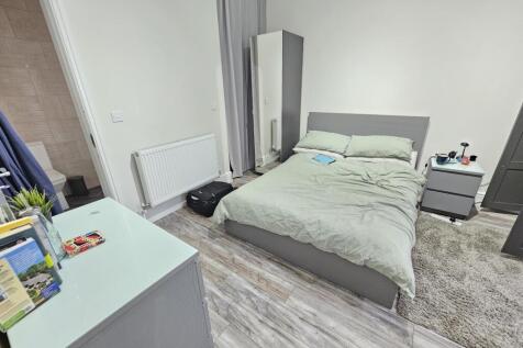 A modern, neatly arranged bedroom featuring a c...