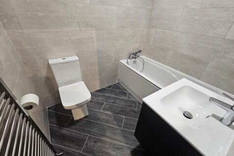 A modern bathroom suite featuring a bathtub, to...