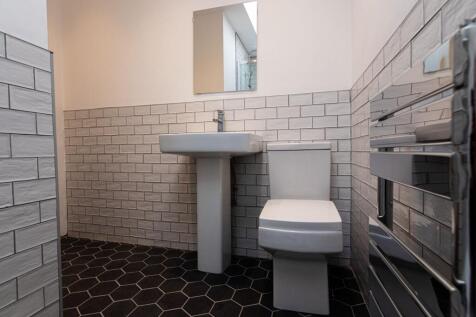 Modern tiled bathroom with a pedestal sink, con...