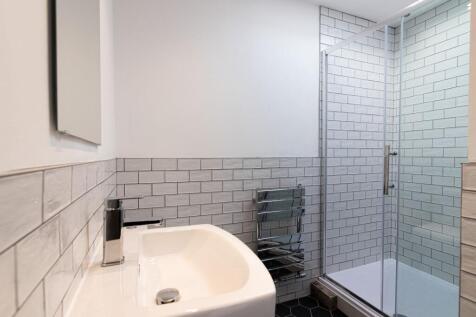 Modern tiled bathroom with a clean white basin,...