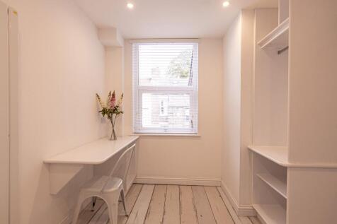 Bright, minimalist single bedroom with a built-...