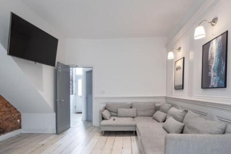 Bright, modern living room with a large L-shape...