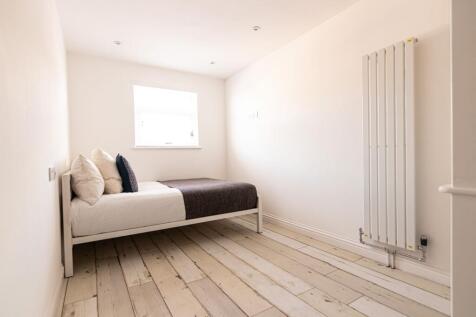 Bright, minimalist single bedroom with a comfor...