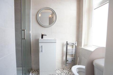 Bright, modern bathroom with a glass shower enc...