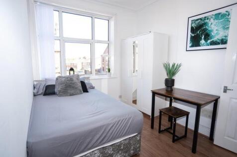 Bright, neatly presented bedroom with a large w...