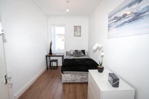 Bright, neatly arranged bedroom with a single b...