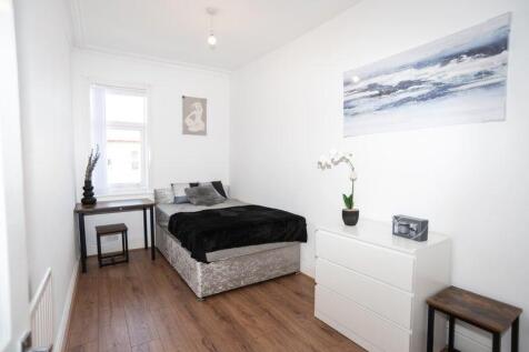 Bright, simply styled double bedroom with a com...