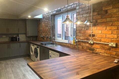 Modern kitchen with warm wood-effect countertop...