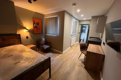 Well-presented double bedroom with a wooden bed...