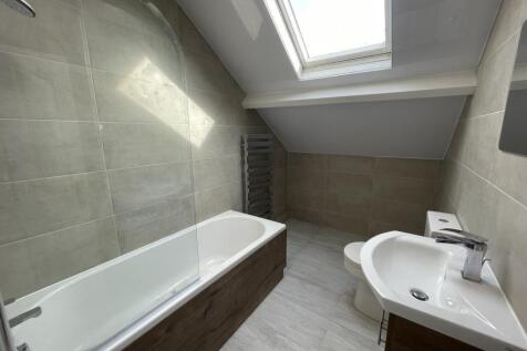 Bright modern bathroom with a fitted bathtub, c...