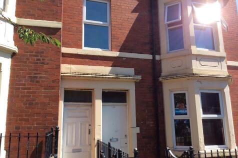 Red-brick terraced house frontage with bay wind...